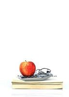 Apple fruit on calculator and book notes on white background photo