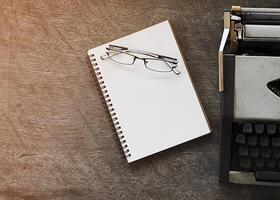 Gafas con notas de libros y máquina de escribir antigua foto