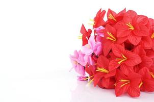 Red plastic flowers isolated on white background photo