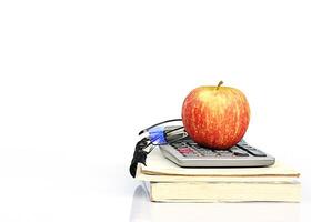 Frutos de manzana roja en la pila de libros y calculadora con gafas foto