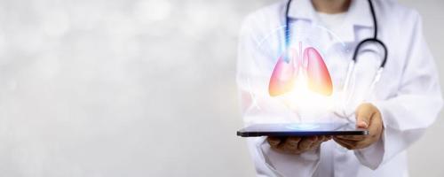 médico que trabaja en la tableta y comprueba los pulmones en la exploración y el tratamiento de tecnología médica por parte de un nuevo especialista en aplicaciones digitales foto