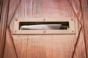 Agujero de casilla de correo en puerta de madera con letra foto