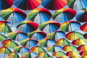 Colorful background of beautiful umbrellas against the blue sky photo