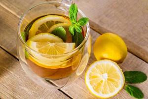 té con limón y menta en taza transparente foto