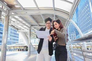 los turistas asiáticos están verificando la información sobre el alojamiento y las atracciones durante el concepto de vivir una pareja feliz foto