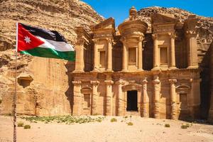 Bandera de Jordania y ad deir también conocido como el monasterio ubicado en Petra en Jordania foto