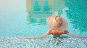 Mujer asiática relajarse y disfrutar de la piscina al aire libre