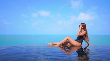 mulher asiática relaxando e aproveitando a piscina ao ar livre video