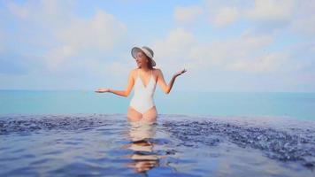 mulher asiática relaxando e aproveitando a piscina ao ar livre video