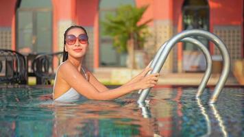 Aziatische vrouw ontspannen en genieten rond het buitenzwembad outdoor video