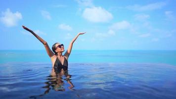 la donna asiatica si rilassa e si diverte intorno alla piscina all'aperto video