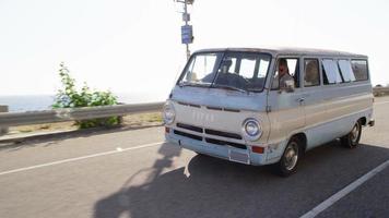 Group of young people on road trip driving old van video