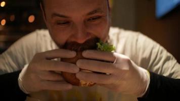 hombre con barba muerde una hamburguesa video