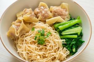 Dried egg noodles with pork wonton or pork dumplings without soup - Asian food style photo