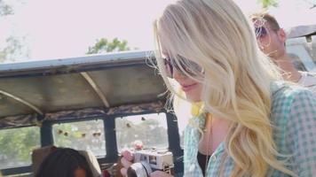 Young woman taking photos with vintage camera on road trip video