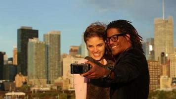 Couple talking self portrait in front of city skyline video