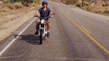 jovem dirigindo motocicleta no deserto video
