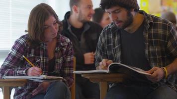 estudantes universitários sentados em sala de aula estudando video