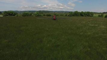 Aerial shot of tractor spraying grass seed farm video