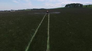 Toma aérea del tractor rociar la granja de semillas de césped video