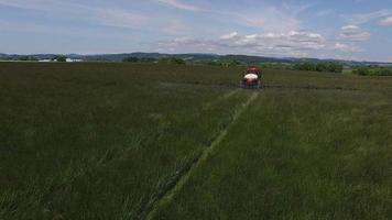 Toma aérea del tractor rociar la granja de semillas de césped video