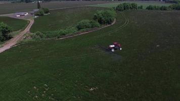 photo aérienne d'un tracteur pulvérisant une ferme de semences de graminées video