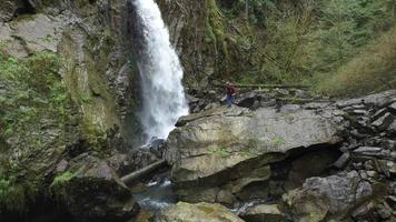 Luftaufnahme eines Backpackers, der Fotos vom Wasserfall macht video