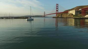Sailboat and Golden Gate Bridge in San Francisco, California, aerial shot video