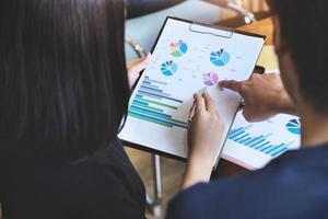 Focus on hand holding pen that points to chart document photo