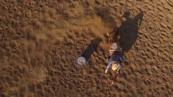 Overhead-Luftaufnahme einer Frau, die auf einem Pferd um das Fass herumreitet video