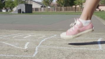 Young girl playing Hopscotch at park, closeup of feet video