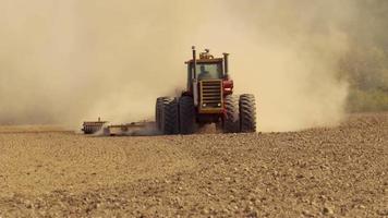 Tractor plowing field in slow motion video