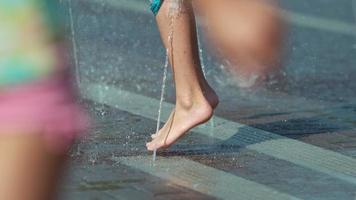 Closeup up of child's feed jumping in fountain, Slow motion video