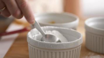 Measuring teaspoon of baking powder into mixing bowl video