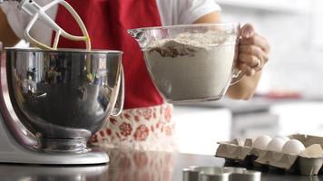 Scooping ingredients into electric mixer video