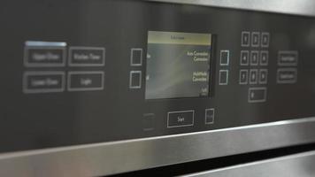 close-up van vrouw in keuken die oven voorverwarmt video