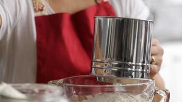 Closeup of woman sifting flour in kitchen video
