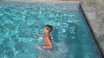 Boy jumping into pool in super slow motion video