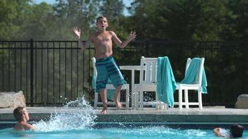 pojke hoppar i poolen i super slow motion