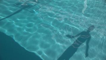 menino dando voltas na piscina em câmera super lenta video