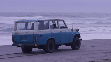 Group of friends driving suv at beach video