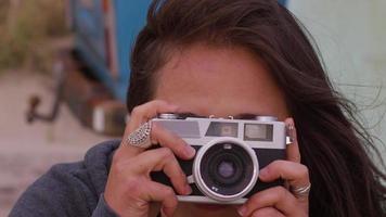 Girl at beach taking photos with vintage camera video