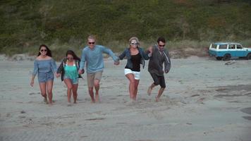 Super slow motion shot of group of friends running at beach, shot with Phantom Flex 4K video