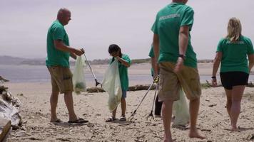 Group of volunteers cleaning up beach video