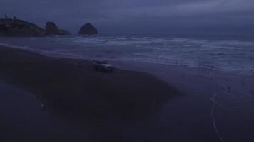 Aerial view of group of friends driving on beach in vintage vehicle video