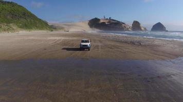 Aerial view of group of friends driving on beach in vintage vehicle video