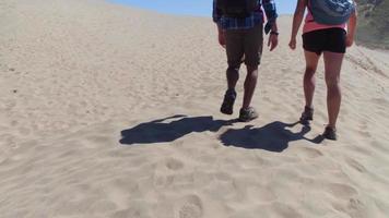 casal caminhando em dunas de areia video