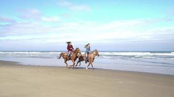 vrouwen die paarden berijden op het strand video