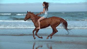 tir au ralenti super d'une femme à cheval sur la plage, dans l'Oregon, tourné sur un flex fantôme 4k video