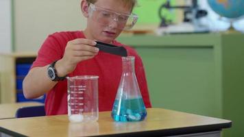 menino de escola trabalhando em um experimento científico video